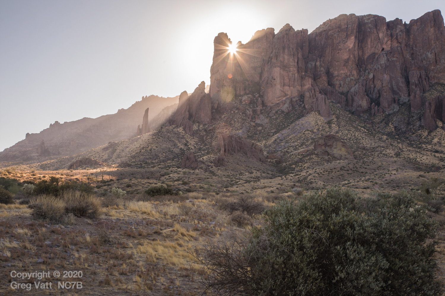 The morning sun is peaking out behind the Superstition Mountains.